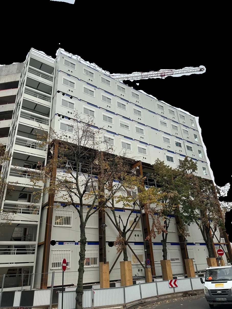 Chantier de construction modulaire en zone urbaine dense avec grue à tour, levage de modules préfabriqués à Paris
